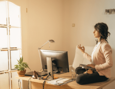 Frau macht Yoga auf dem Bürotisch